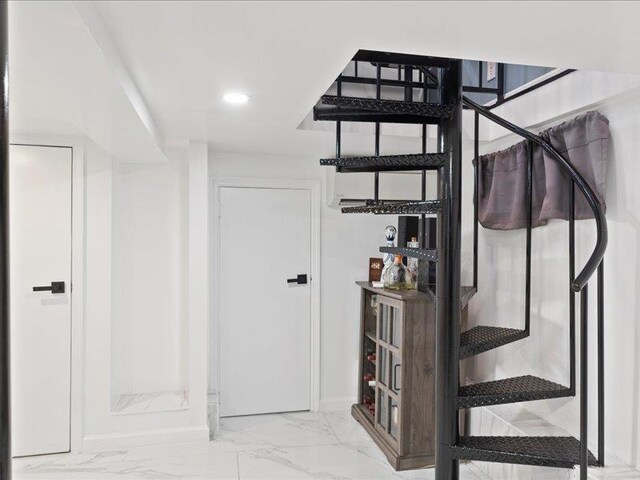 stairway with marble finish floor and recessed lighting