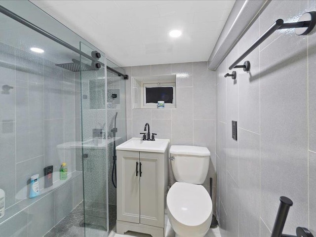 bathroom featuring a stall shower, toilet, tile walls, and vanity