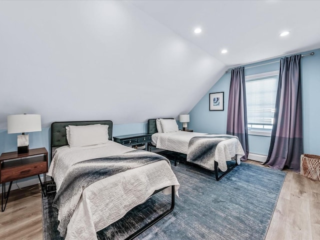 bedroom featuring vaulted ceiling, baseboard heating, recessed lighting, and light wood-style floors