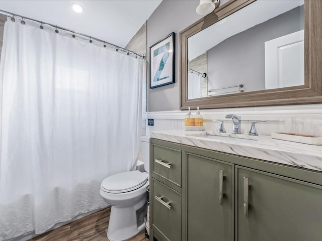 bathroom featuring shower / bath combo, wainscoting, toilet, wood finished floors, and vanity