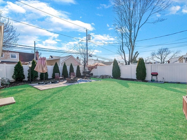 view of yard with an outdoor fire pit, a fenced backyard, and a patio