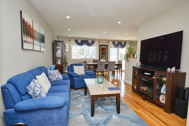 living room featuring light wood finished floors, baseboards, and recessed lighting