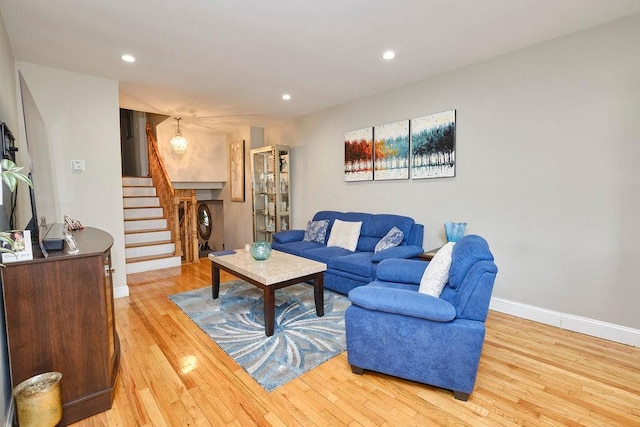 living room with recessed lighting, stairway, light wood-type flooring, and baseboards