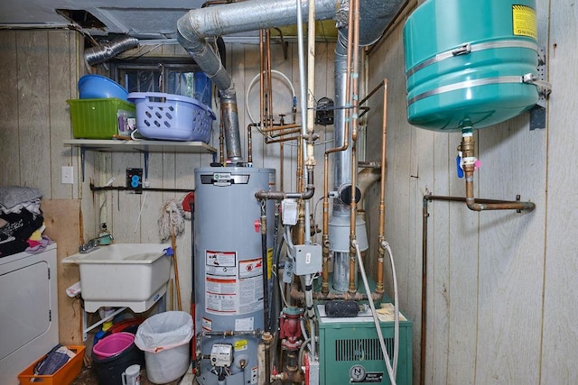 utilities with washer / clothes dryer, gas water heater, a heating unit, and a sink