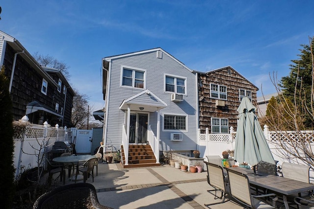 rear view of property featuring outdoor dining area, a patio, entry steps, fence, and cooling unit