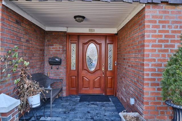 doorway to property featuring brick siding