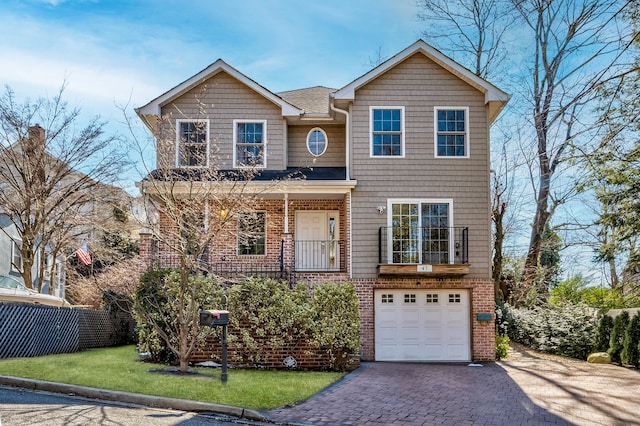 traditional-style home with brick siding, decorative driveway, a front yard, and fence