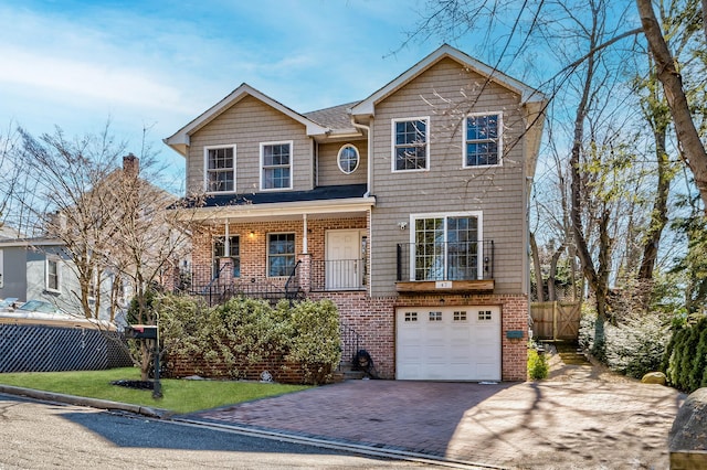 view of front of house featuring brick siding, decorative driveway, an attached garage, and fence