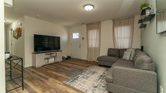 living area featuring dark wood-type flooring and baseboards