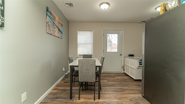 dining area featuring visible vents, dark wood finished floors, and baseboards