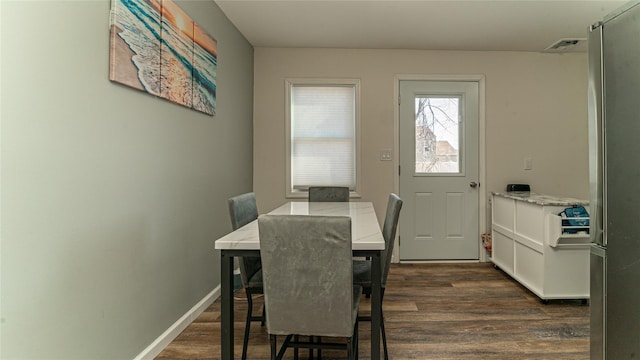 dining area with baseboards, visible vents, and dark wood-style flooring