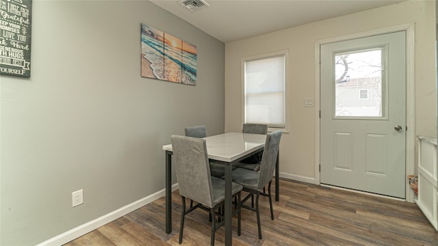 dining space featuring dark wood finished floors, visible vents, and baseboards