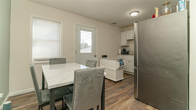 dining area with dark wood-style floors and baseboards