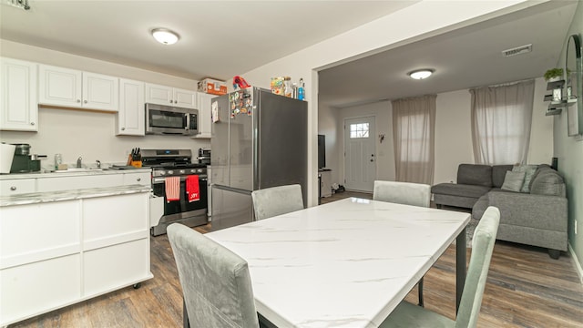 dining room featuring visible vents and dark wood-type flooring