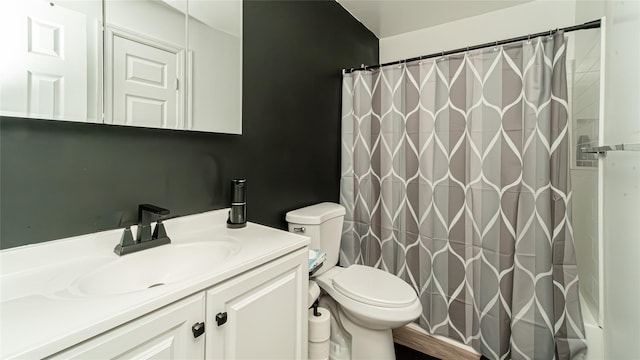 bathroom with curtained shower, vanity, and toilet