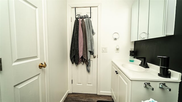 bathroom featuring wood finished floors, vanity, and baseboards