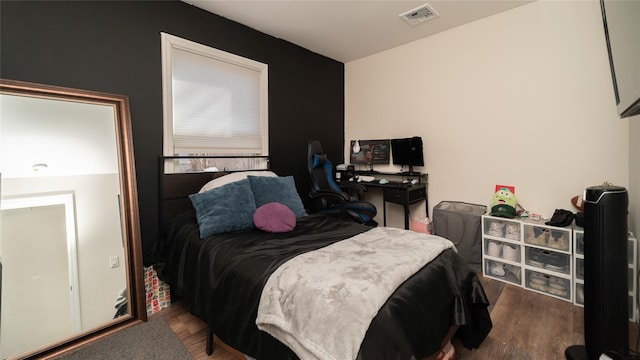 bedroom with visible vents and wood finished floors