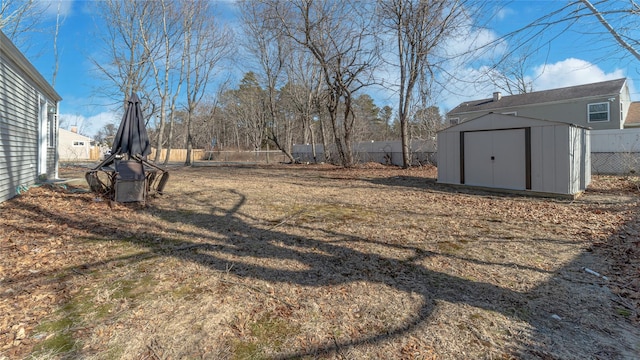 view of yard featuring an outbuilding, a storage unit, and a fenced backyard