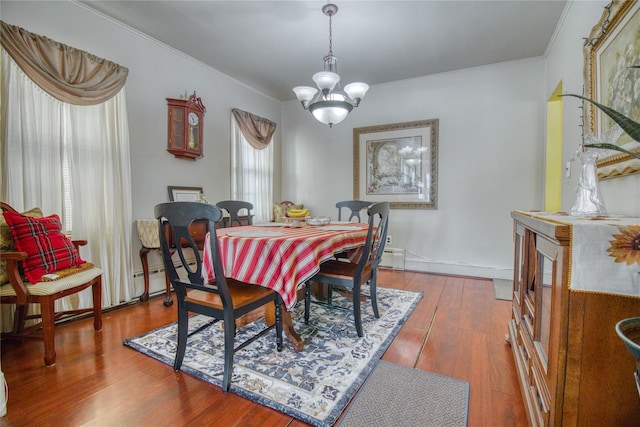 dining area featuring a chandelier, crown molding, and wood finished floors