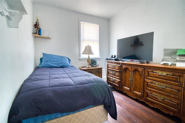 bedroom featuring ornamental molding and dark wood-style flooring