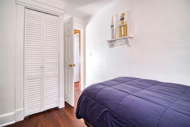 bedroom featuring a closet, wood finished floors, and crown molding