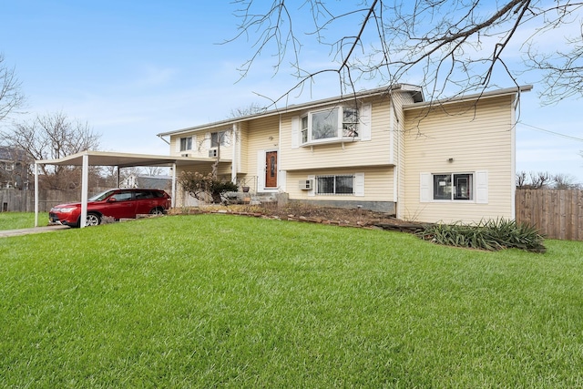 split foyer home featuring a front lawn and fence