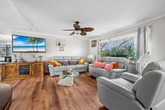 living area with ceiling fan, ornamental molding, and wood finished floors