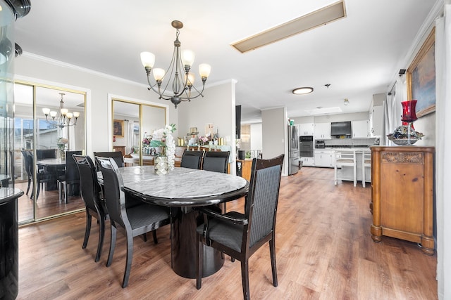 dining room with a chandelier, light wood-type flooring, and crown molding