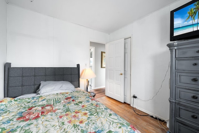 bedroom with light wood-type flooring and baseboards