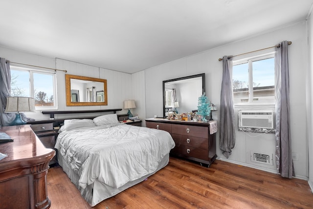 bedroom featuring visible vents, cooling unit, and wood finished floors