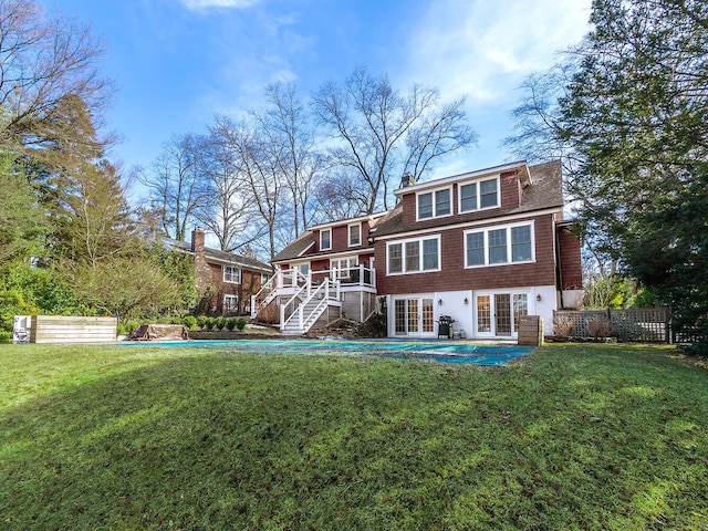 back of house featuring a yard, stairs, fence, french doors, and a pool