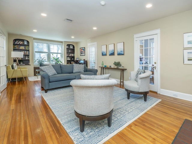 living area with wood finished floors, visible vents, and recessed lighting