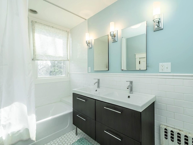 full bath with tile walls, wainscoting, radiator heating unit, tile patterned flooring, and a sink