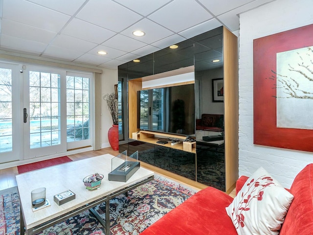 living area featuring a drop ceiling, wood finished floors, and recessed lighting