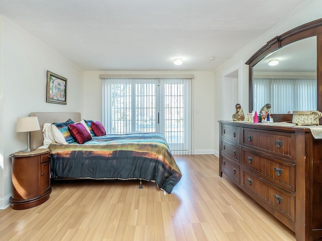 bedroom featuring light wood-style floors, ornamental molding, and baseboards