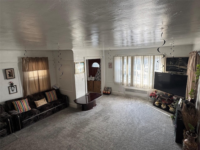 living room with radiator, carpet flooring, and a textured ceiling