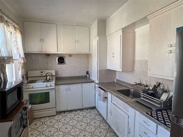 kitchen featuring white gas stove, visible vents, decorative backsplash, a sink, and black microwave