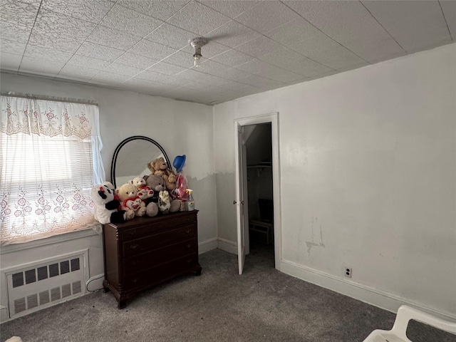 carpeted bedroom featuring baseboards and radiator heating unit