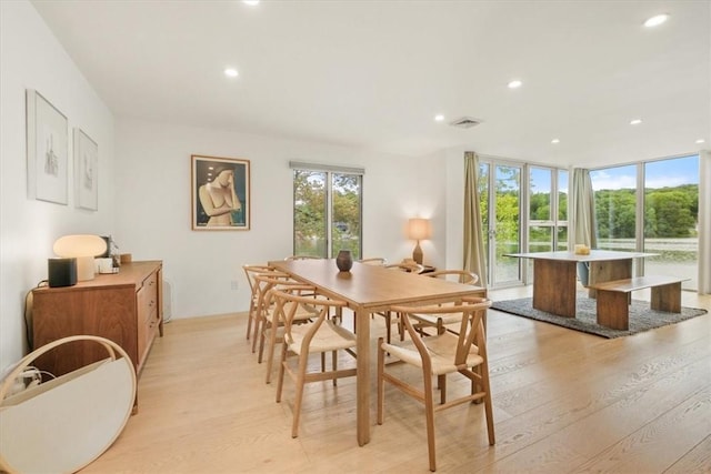 dining area featuring expansive windows, light wood finished floors, visible vents, and recessed lighting