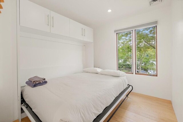 bedroom with recessed lighting, visible vents, and wood finished floors