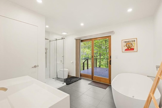 bathroom featuring a stall shower, a soaking tub, tile patterned flooring, and recessed lighting