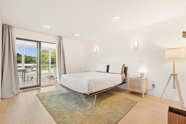 bedroom featuring access to outside, light wood-type flooring, and recessed lighting