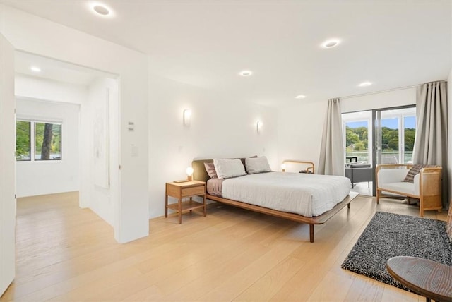 bedroom with light wood-style floors, recessed lighting, access to outside, and multiple windows