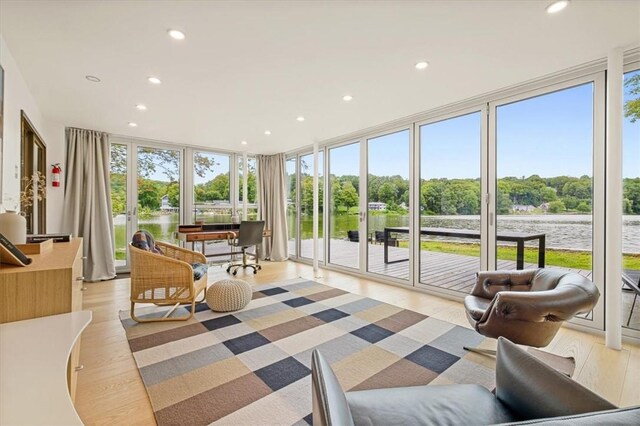 sunroom featuring a water view