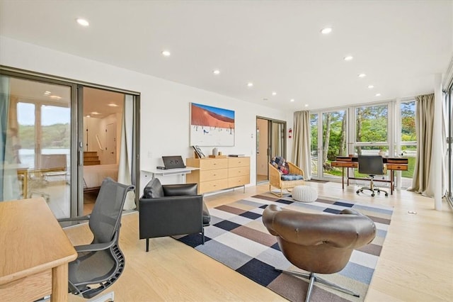 interior space with a wall of windows, recessed lighting, and wood finished floors