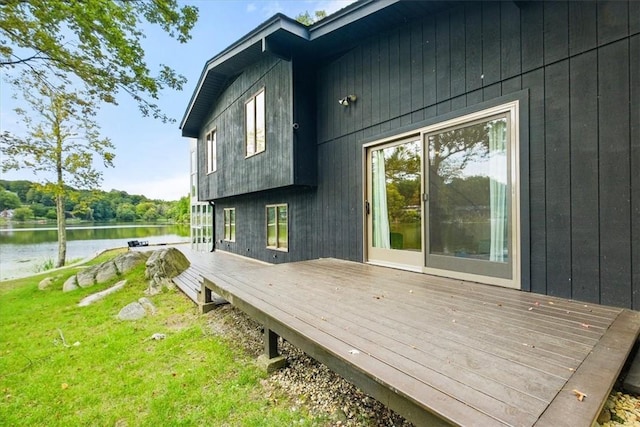 deck featuring a water view and a lawn