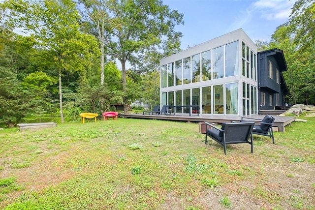 rear view of property featuring a yard and a sunroom