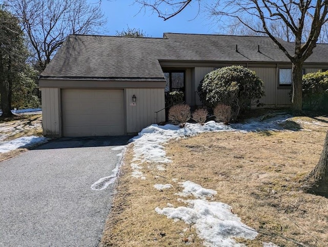 view of front of property with a garage, driveway, and roof with shingles