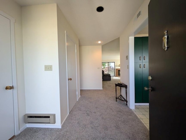 corridor featuring light colored carpet, visible vents, and baseboards