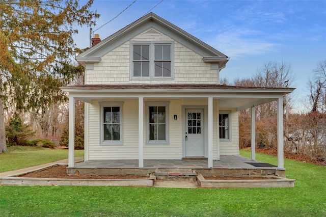 farmhouse with covered porch, a chimney, and a front lawn